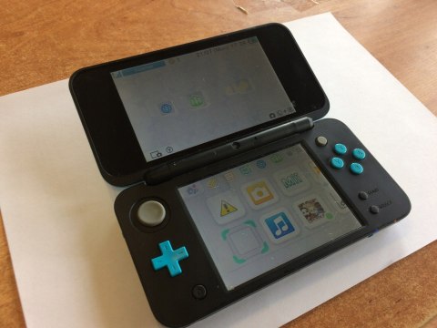 KONSOLA NEW NINTENDO 2DS XL NIEBIESKO-CZARNA + ŁADOWARKA + RYSIK KONSOLA NEW NINTENDO 2DS XL NIEBIESKO-CZARNA + ŁADOWARKA + RYSIK