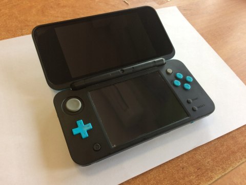 KONSOLA NEW NINTENDO 2DS XL NIEBIESKO-CZARNA + ŁADOWARKA + RYSIK KONSOLA NEW NINTENDO 2DS XL NIEBIESKO-CZARNA + ŁADOWARKA + RYSIK