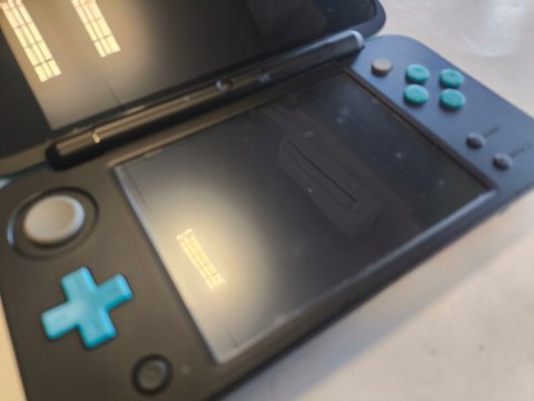 KONSOLA NEW NINTENDO 2DS XL NIEBIESKO-CZARNA + ŁADOWARKA + RYSIK + ETUI KONSOLA NEW NINTENDO 2DS XL NIEBIESKO-CZARNA + ŁADOWARKA + RYSIK + ETUI